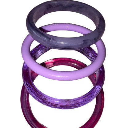 Four stacked translucent bangles in shades of purple, lavender, magenta, and deep violet on a plain white background by Gypsy Soul Doll.