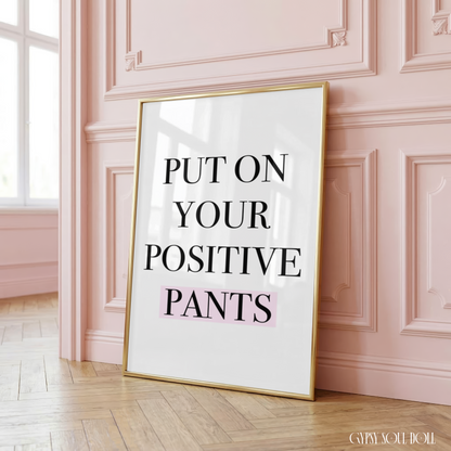 Inspirational A4 wall art print reading Put On Your Positive Pants in a tall black serif font with a soft pastel pink highlight bar on a clean borderless canvas background.