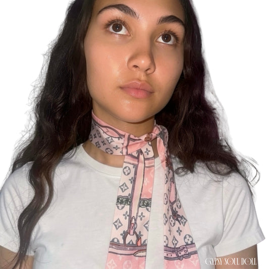 Model showcasing the Gypsy Soul Doll pink monogram skinny satin scarf wrapped elegantly as a multi-way neck tie choker styled with a white t-shirt.