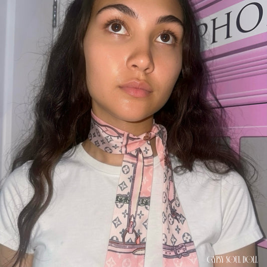 Model showcasing the Gypsy Soul Doll pink monogram skinny satin scarf wrapped elegantly as a multi-way neck tie choker styled with a white t-shirt.