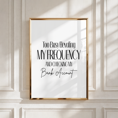 A4 vertical art print with a white background featuring tall black editorial serif typography combined with a black cursive script font that reads Too Busy Elevating MY FREQUENCY AND CHECKING MY Bank Account without punctuation.