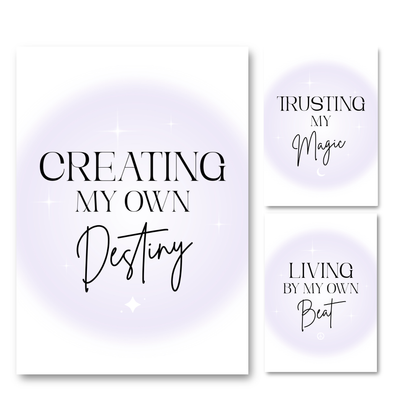 Three vertical wall art prints with inspirational typography on a white background. The left print reads 'CREATING MY OWN Destiny' and the right prints read 'TRUSTING MY Magic' and 'LIVING BY MY OWN Beat'.