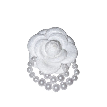 Close-up front view of the frosted white velvet camellia flower brooch pin decorated with elegant double-layered draped faux pearl bead loops.
